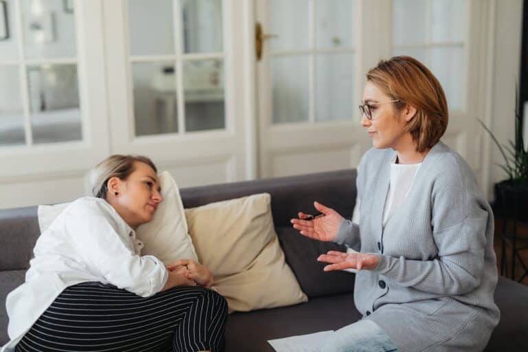 women-sitting-on-a-couch-and-talking
