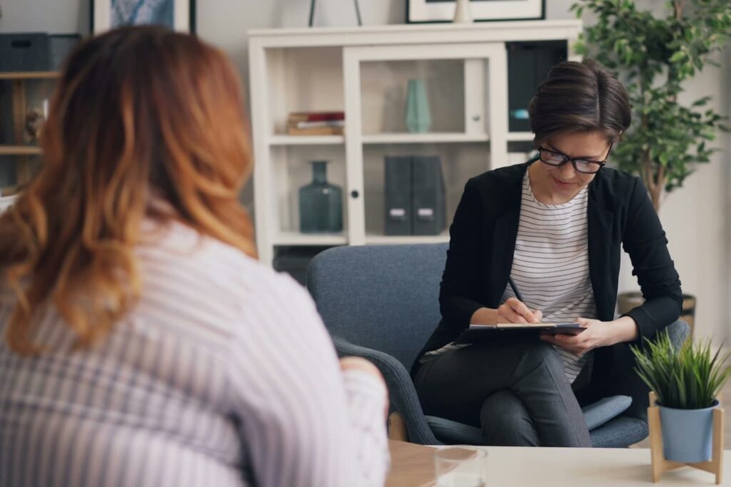 a-woman-sitting-on-a-couch-with-a-clipboard-in-her-hand
