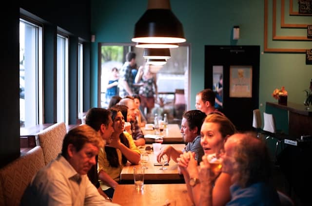 people-sitting-beside-brown-wooden-table-inside-room
