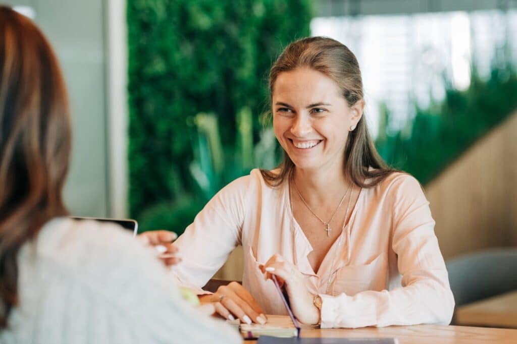 young-happy-woman-smiling-and-talking-with-colleague